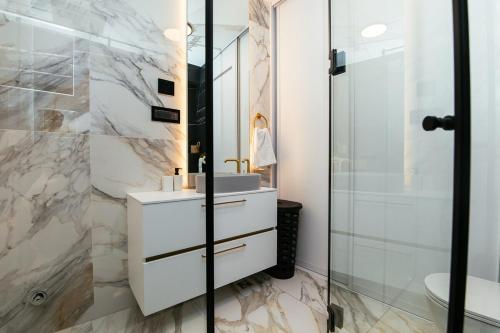 ザグレブにあるLuxury Apartmentの洗面台とガラスのシャワーを備えたバスルーム