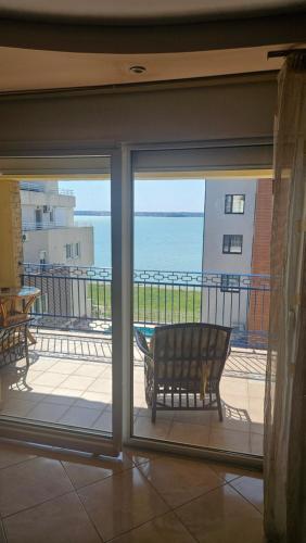 a sliding glass door with a bench on a balcony at Eva apartments in Mamaia