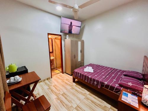 a room with a bed and a tv on the wall at Habitación Céntrica en Iquitos - Casa Alemi 1 in Iquitos