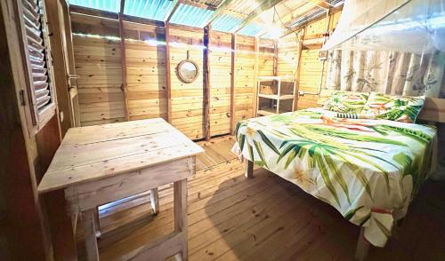 a bedroom with a bed and a table in a cabin at Buen Hombre Kite School with Accommodations in La Costa de Buen Hombre