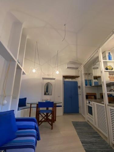a living room with blue chairs and a table at Occhio sul mare in Isola del Giglio