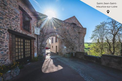an archway in a brick building with the sun shining at Maison en Pierre avec Jardin 4 Voyageurs in Luré