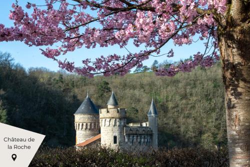 a castle with pink flowers on a hill with a tree at Maison en Pierre avec Jardin 4 Voyageurs in Luré