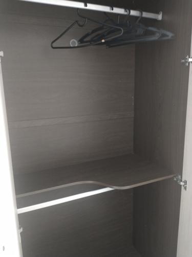 a closet with a wooden shelf in a room at Casa Ampla em Boituva-SP in Boituva
