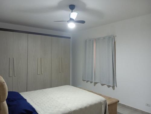 a bedroom with a bed and a ceiling fan at Casa Ampla em Boituva-SP in Boituva
