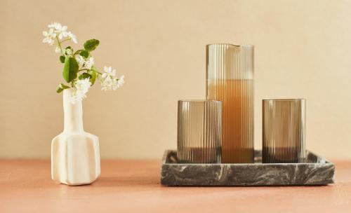 a vase with a flower in it next to three candles at Locanda Ca' Matilde in Quattro Castella