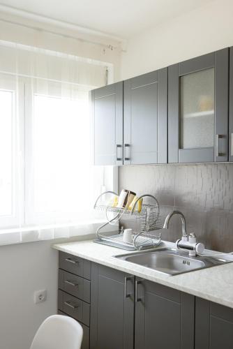 a kitchen with white cabinets and a sink at Apartman Natura in Vrnjačka Banja