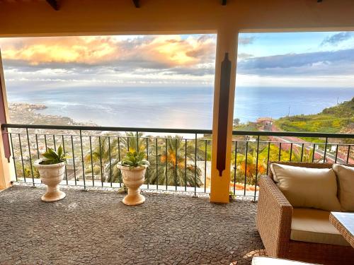 a balcony with potted plants and a view of the ocean at Villa Michelangelo in Câmara de Lobos