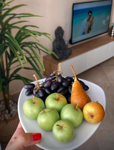 a plate with apples and other fruits on a table at CAPTAIN'S RESIDENCE in Ksamil