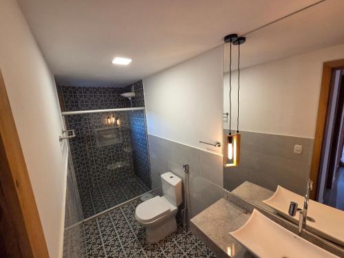 a bathroom with a shower and a toilet and a sink at Casa Ilhéus in Ilhéus
