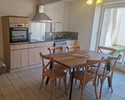 - une cuisine avec une table et des chaises en bois dans l'établissement La Villa Cécile, à Saint-Martin-de-Villereglan