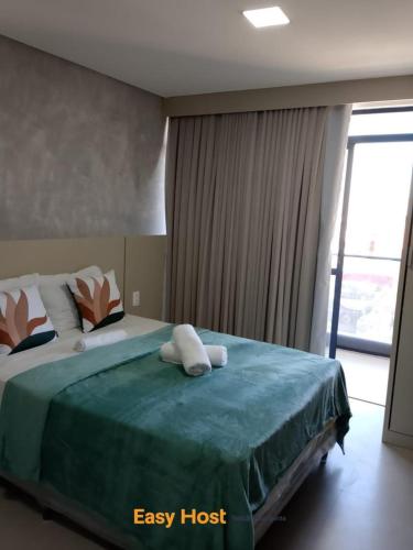 a bedroom with a large bed with a large window at Flats Tramonto - By EasyHost in João Pessoa