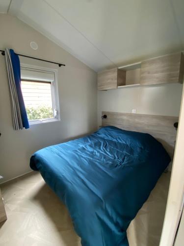 - une chambre avec un lit bleu dans l'établissement Mobilehome Balzac 2 -3ch-Magnifique Vue mer, à Saint-Raphaël