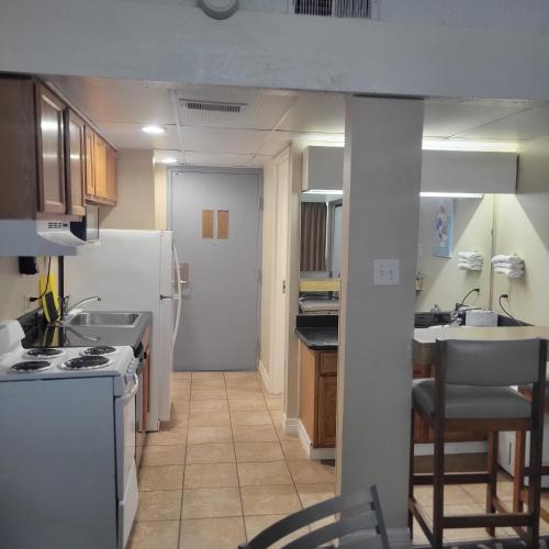 a kitchen with a white refrigerator and a stove at Padre South Hotel On The Beach in South Padre Island