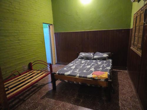 Una habitación con una cama y un banco dentro. en Hospedaje24hs, en Argentina