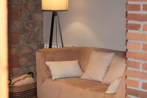 a brown couch with two white pillows on it at La Frau, Casa rústica al Parc Natural del Montseny in Arbúcies