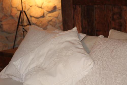 a white bed with two pillows on it at La Frau, Casa rústica al Parc Natural del Montseny in Arbúcies