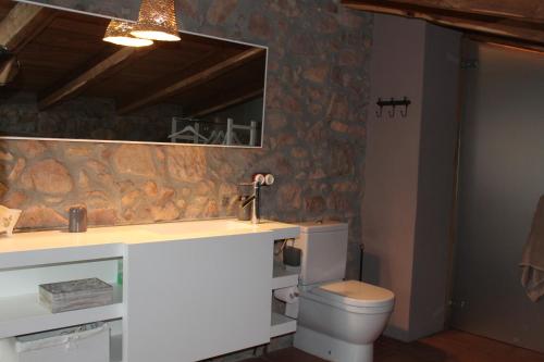 a bathroom with a sink and a toilet and a mirror at La Frau, Casa rústica al Parc Natural del Montseny in Arbúcies