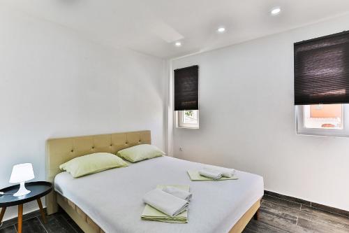 a bedroom with a bed with two towels on it at Apartmani BLUE MOON in Dobra Voda