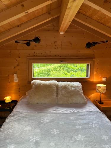Ce lit se trouve dans une chambre en bois dotée d'une fenêtre. dans l'établissement Small cottage, à Contamine-sur-Arve