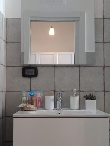a bathroom counter with a sink and a mirror at Kairòs - locazione turistica in Torre Annunziata