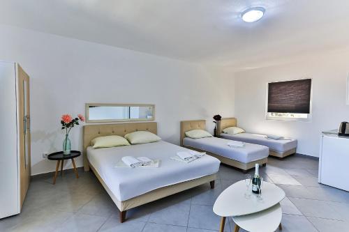 a hotel room with two beds and a table at Apartmani BLUE MOON in Dobra Voda