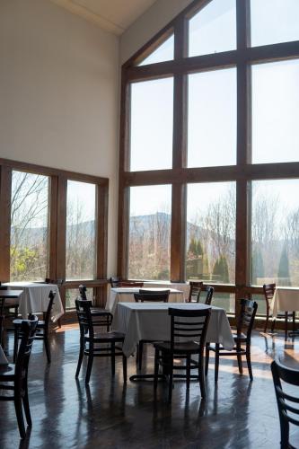 a dining room with tables and chairs and large windows at Inn at Crestwood in Boone