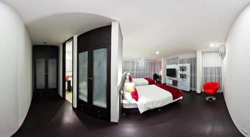 a bedroom with a large bed and a red chair at Monterosa Apartamentos Amoblados in Pereira