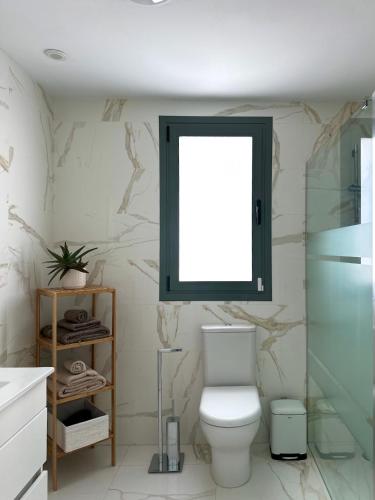 a bathroom with a toilet and a window at Casa Elegante Casares Costa Golf in Casares