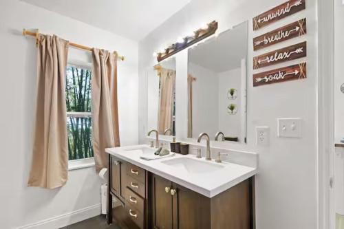 a bathroom with a sink and a mirror at Anastasia Island Treehouse in St. Augustine