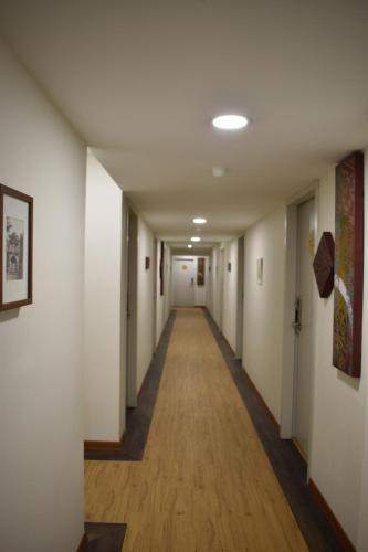 a hallway of an office building with white walls and wooden floors at Xpeed Holiday Hotel in Kuala Lumpur