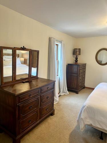 a bedroom with a dresser and a mirror and a bed at The Smiling Bear Cabin in Two Rivers