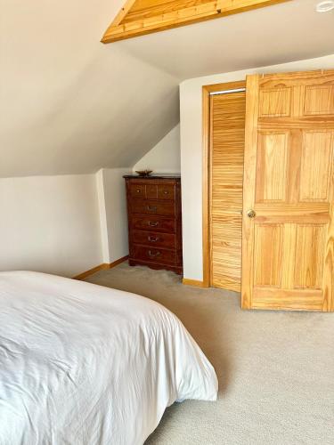 a bedroom with a bed and a wooden door at The Smiling Bear Cabin in Two Rivers