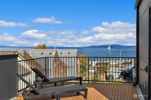 a balcony with a bench and a view of the water at Alki Beach Front TownHome in Seattle