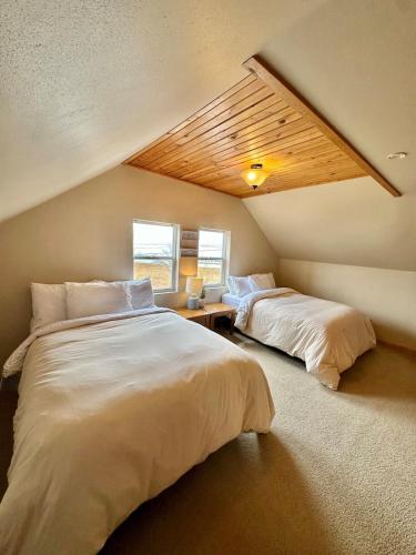 a bedroom with two beds and a slanted ceiling at The Smiling Bear Cabin in Two Rivers