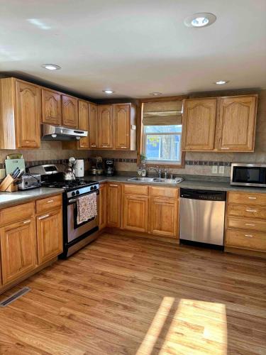 a kitchen with wooden cabinets and a stove top oven at The Smiling Bear Cabin in Two Rivers