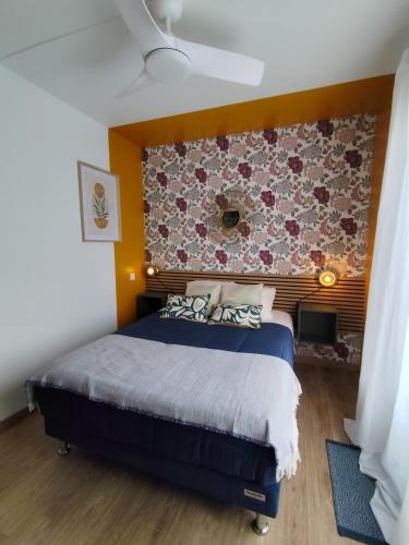 a bedroom with a blue bed and a wall at Dousserença in Bressols