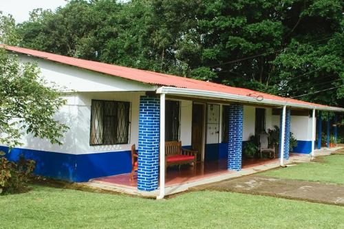 a house with a red roof and blue accents at Casa Posada Margarita in Bijagua