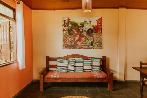 a bench in a room with a painting on the wall at POUSADA e BANGALOS VILA DA BARCA in Ilha de Boipeba