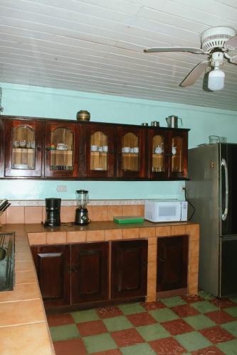 a kitchen with wooden cabinets and a refrigerator at Casa Posada Margarita in Bijagua