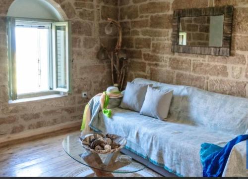 a living room with a couch and a glass table at Old Mansion Residence in Riglia