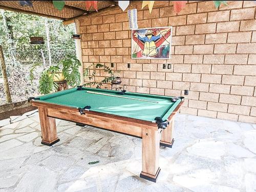 a pool table in front of a brick wall at Sítio Quinta da mata - Casa Amarela in Pirenópolis