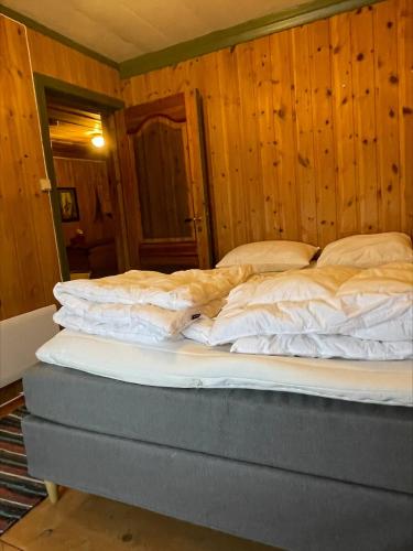 a large bed in a room with wooden walls at Koselig tømmerhus på gammel gård i Skåbu in Graupe
