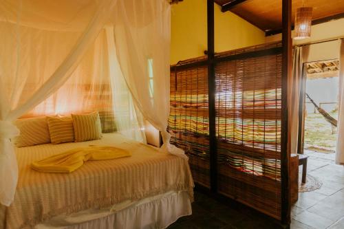 a bedroom with a bed and a window at POUSADA e BANGALOS VILA DA BARCA in Ilha de Boipeba