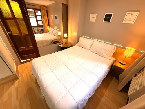 a small bedroom with a bed and a mirror at Casa Recoleta - Hoteles Recoleta in Buenos Aires