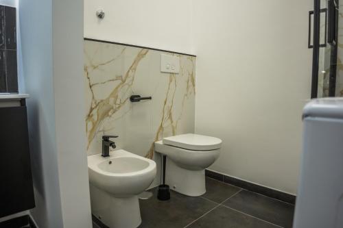 a bathroom with a toilet and a sink at Almar Living - Signature Apartments in Taranto
