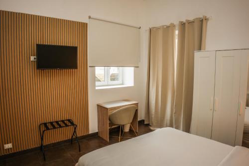 a bedroom with a bed and a desk and a television at Almar Living - Signature Apartments in Taranto