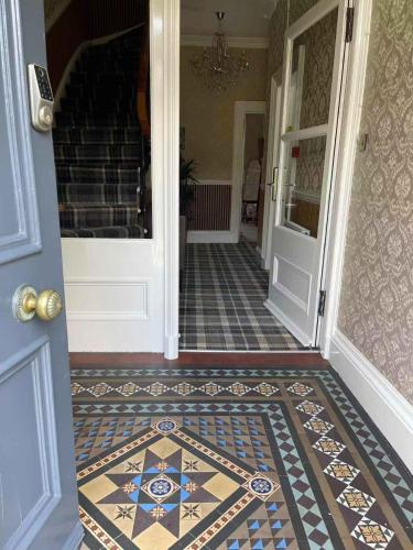 a hallway with a door and a tile floor at Kingston Guesthouse in Edinburgh