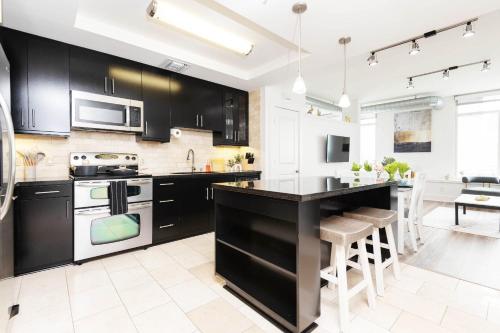 a kitchen with black cabinets and a kitchen island at Sky-Rise Apartments in Los Angeles
