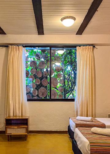 a room with two beds and a large window at Viajero Salento Hostel in Salento